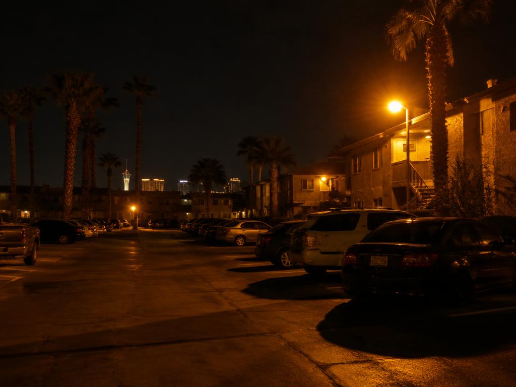 Dim orange high-pressure sodium lighting in a Las Vegas apartment community parking lot at night